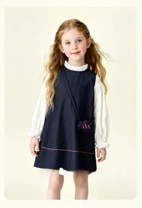 Detail of navy blue denim pinafore dress with white lace ruffle collar shirt for girls