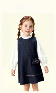 Close-up of girls denim sleeveless dress with white ruffled shirt and cloud-shaped bag