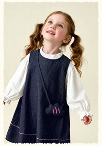 Detail of girls denim jumper dress with lace collar white shirt and cloud bag