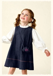 Detail of girls' white ruffle collar shirt with navy blue pinafore dress and cloud bag