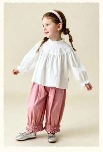 Detail of girls' long sleeve ruffled collar top and pink pants with bow shoes
