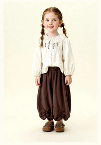 Detail of vintage kids shirt with lace collar and brown bloomers pant set