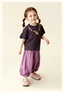 Detail view of purple kids' casual pants featuring elegant ruffled hem and soft cotton fabric
