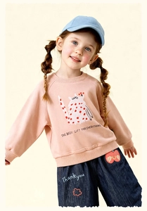 Close-up of girls' pink sweatshirt with cat print and denim wide-leg pants detail
