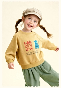 Detail of girls' mustard yellow cartoon sweatshirt and green pleated casual trousers