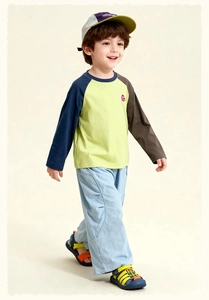 Detail of kids casual set with color-block long sleeve raglan tee and light blue pants