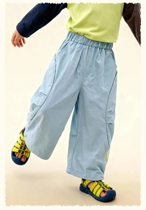 Detail of light blue boys wide-leg trousers with large side pockets and smile print