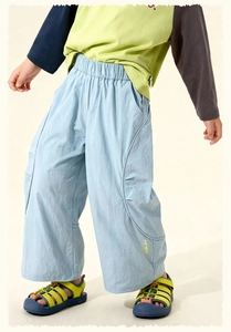Detail of blue cargo pants featuring yellow smile embroidery on the leg hem for kids