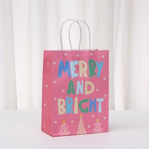 Pink Christmas gift bag with Merry and Bright print and white rope handles