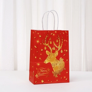 Red Christmas paper gift bag with golden reindeer pattern and white rope handles