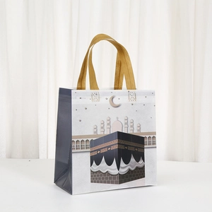 Eid Mubarak non-woven gift bag featuring Kaaba and Mosque silhouettes with gold handles