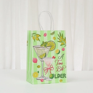 Green striped kraft paper gift bag with cocktail illustration and A Tini Bit Older text