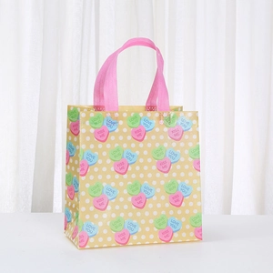 Waterproof non-woven gift bag with colorful hearts and pink handles for party favors