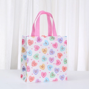 Detail of waterproof non-woven Valentine gift bag with sweet heart patterns and pink handles