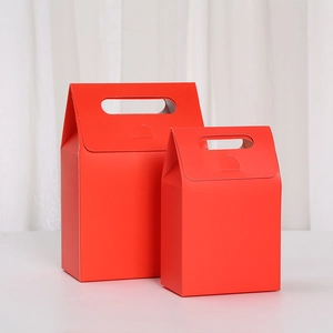 Macro detail of red matte cardboard gift boxes with handles in two different sizes
