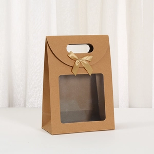 Close-up of brown kraft gift bag with large transparent window and gold silk bow detail
