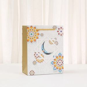 Ramadan gift bag with blue crescent moon and floral geometric patterns on pearly white base