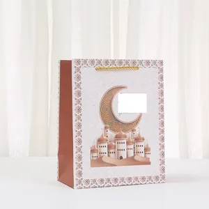 Detail of white festive paper gift bag featuring mosque and golden moon print