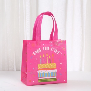 Pink non-woven gift bag with birthday cake print and Take the Cake typography