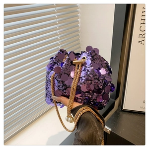 Detail of purple sequin bucket bag with gold chain strap and pearl accents