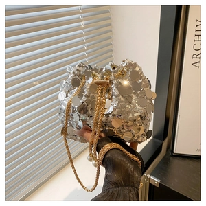 Detail of silver sequin bucket bag with gold chain strap and pearl accents