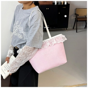 Detail of pink canvas tote bag featuring white lace trim and Tian Yun embroidery