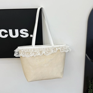 Beige woven tote bag with white lace trim and embroidered letters for casual travel