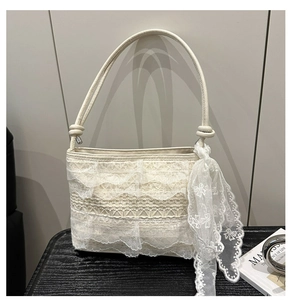 Dettaglio borsa a spalla in pizzo bianco con balze a strati e foulard in seta abbinato