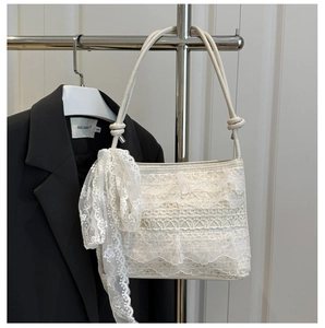 Detailed close-up of the white lace shoulder bag with ruffled layers and matching scarf