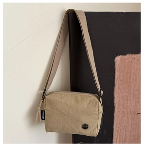 Detail of khaki nylon crossbody bag with pleated texture and FANYISSA side label