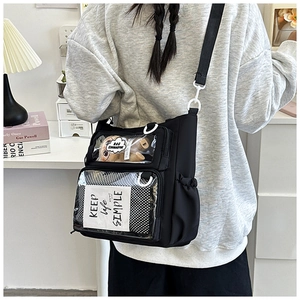 Macro detail of black nylon crossbody bag featuring transparent windows with plush decor