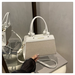 Detail of minimalist tote bag with FASHION BAG text and contrast leather panels