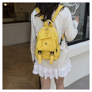 Détail d'un sac à dos en nylon jaune avec fermetures éclair multicouches et sangles réglables