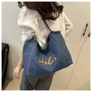 Détail du cabas en jean bleu avec broderie Hello jaune et surpiqûres blanches contrastées