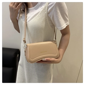Close-up of cream leather shoulder bag with gold FASHION & BAGS lettering and metal buckle