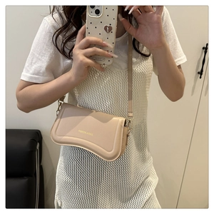 Beige leather shoulder bag with curved flap and Fashion & Bags logo in a mirror selfie