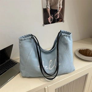 Grand sac cabas en toile bleu clair avec broderie Hello et anses en cuir noir tendance