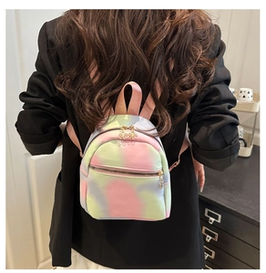 Detail view of a mini pastel gradient backpack with floral zipper charms on a model