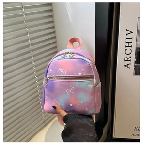 Detailed macro view of rainbow tie-dye mini backpack with heart print and flower zipper