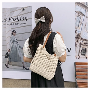 Detail of hollow mesh crochet tote with brown leather strap and metal rivet design