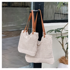 Detail of cream crochet beach bags in two sizes with brown faux leather shoulder straps