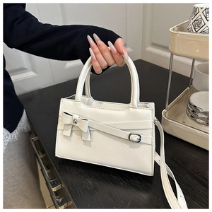 Detailed shot of white leather handbag with bow knot detail and silver hardware