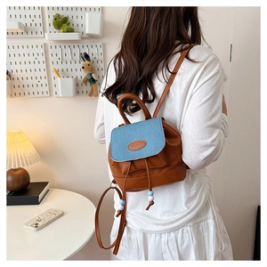 Dettaglio dello zaino mini in ecopelle marrone e tessuto denim blu stile patchwork