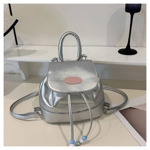 Detail of silver metallic mini backpack with drawstring closure and colorful bead accents
