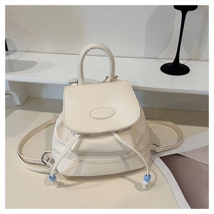 Detail of cream white leather mini backpack with drawstring closure and embossed logo