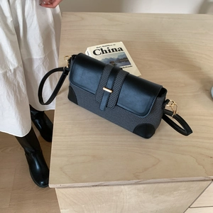 Sac baguette chic avec texture tissée grise et détails de garniture en cuir noir
