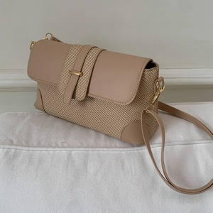 Minimalist baguette shoulder bag with straw and matte leather textures in beige and khaki