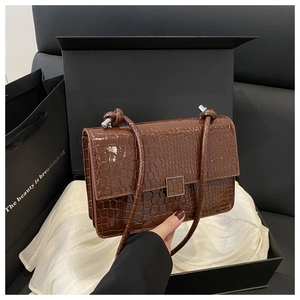 Detailed close-up of dark brown crocodile pattern handbag in premium gift box set