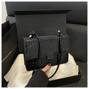 Detail of crocodile embossed crossbody bag with silver buckle in luxury gift box