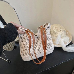 Hollow out woven beach shoulder bag with brown leather straps and gold rivet accents
